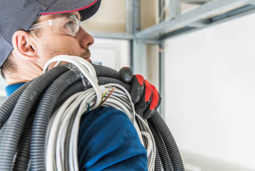 electrician carrying cables over right shoulder