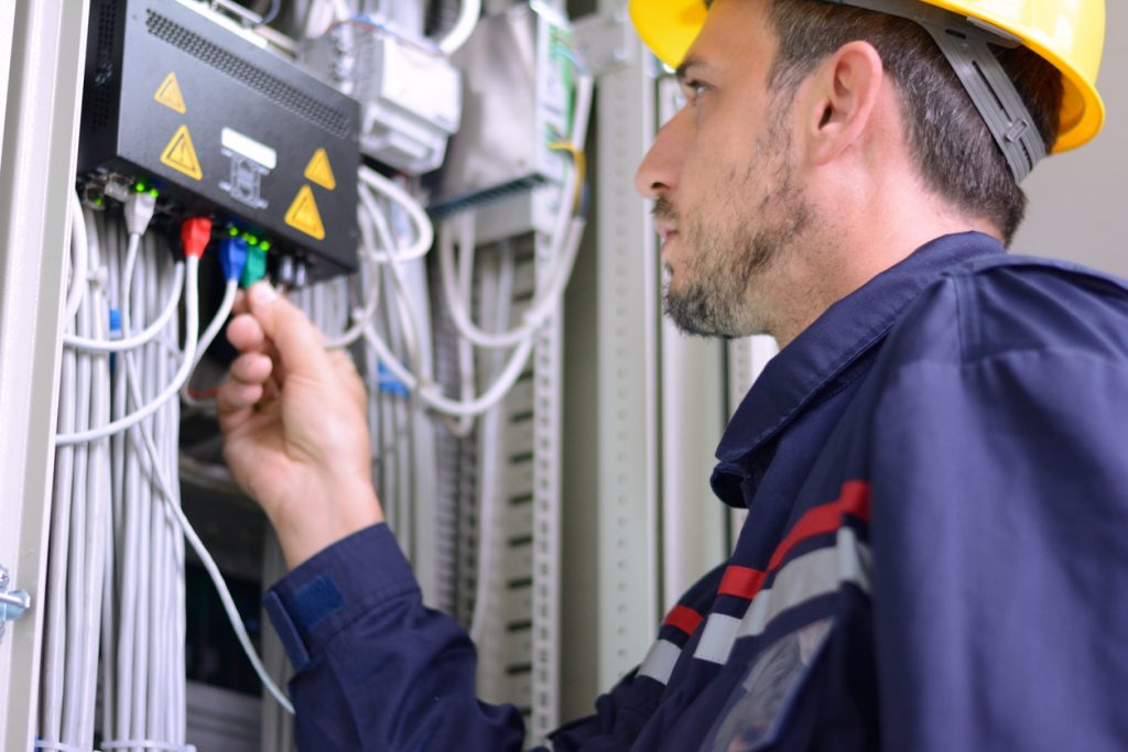 electrician installing cable to switch