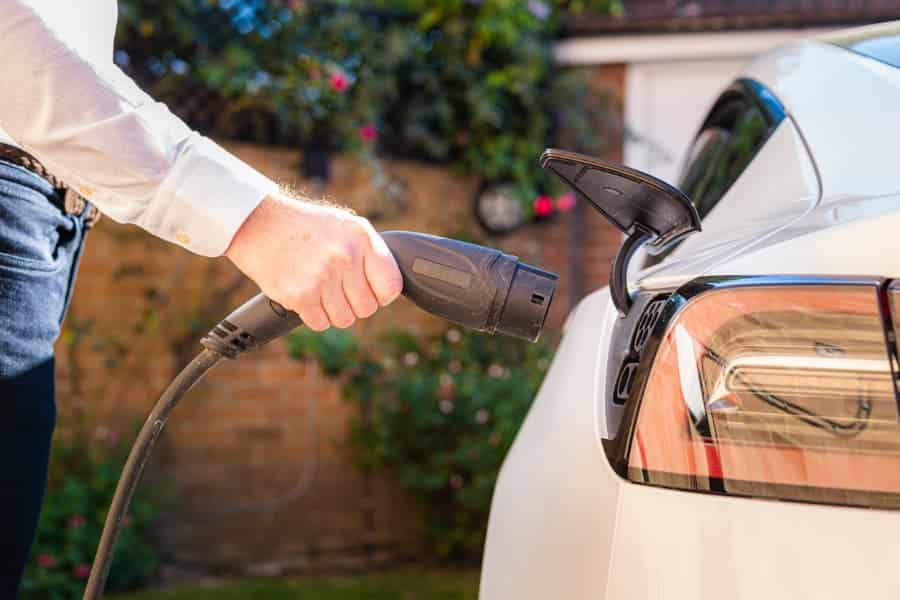 Homeowner charging EV at home in driveway